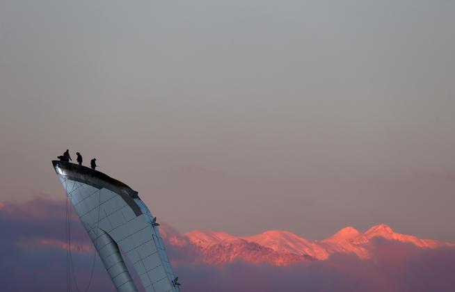 Workers stand atop the cauldron ahead of the Sochi 2014 Winter Olympics at Olympic Park on Sunday.