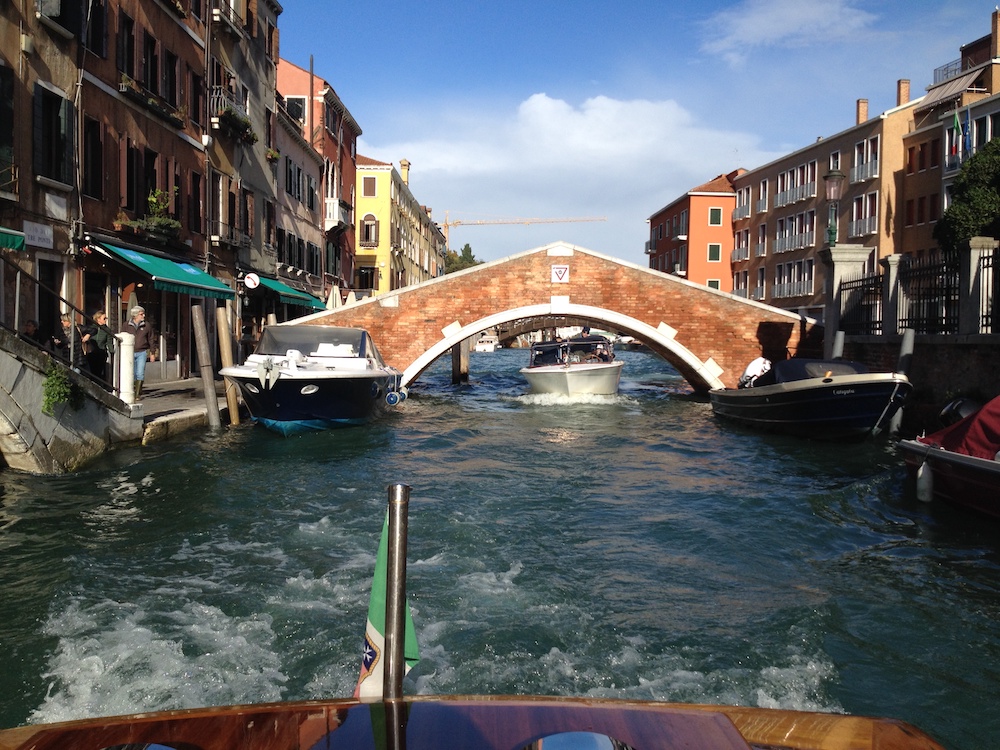 Boat passes under Venice bridge - Venice Tourism